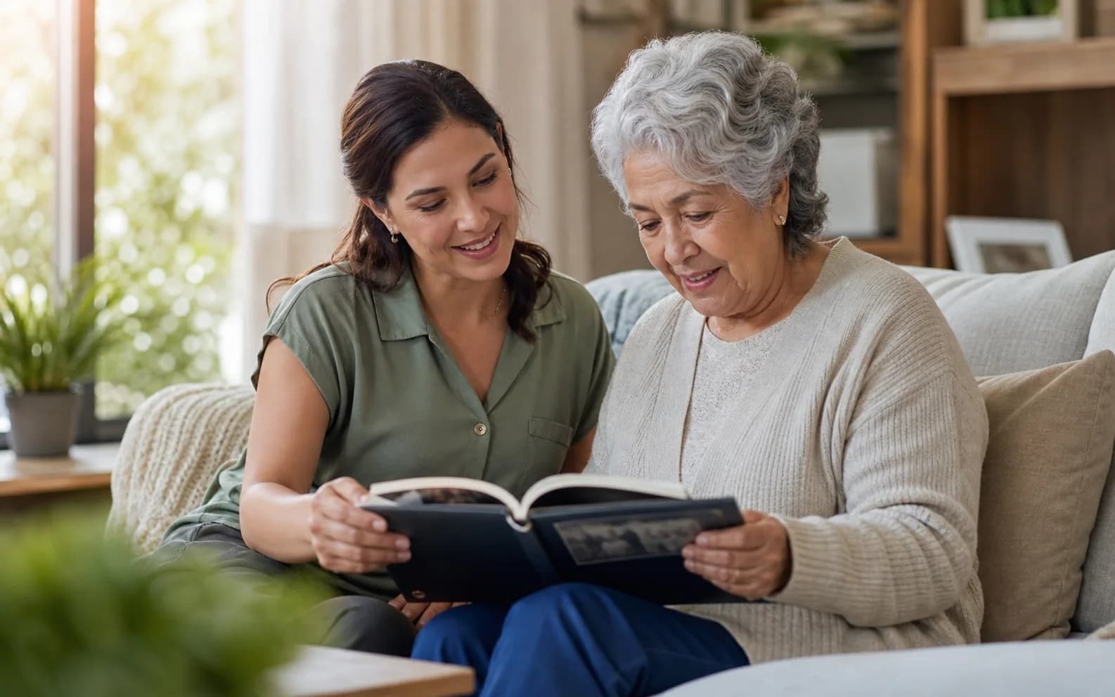 A dementia caregiver and older adult looking through a family photo album together