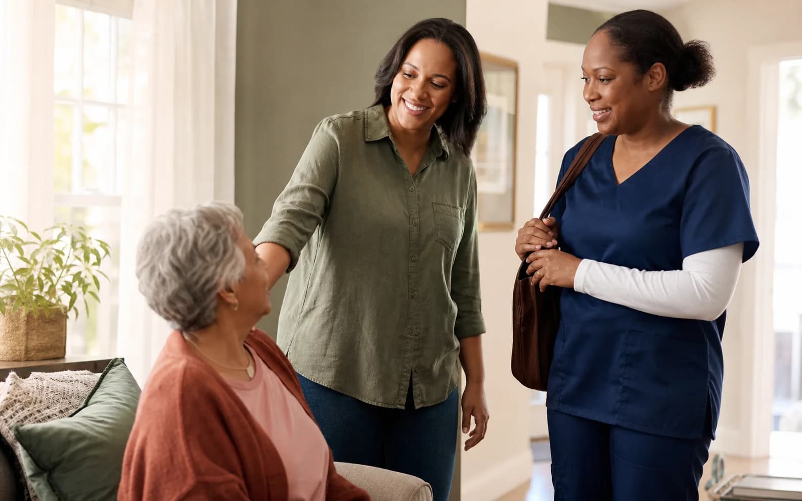 A family caregiver making a reassuring handoff to a professional home caregiver