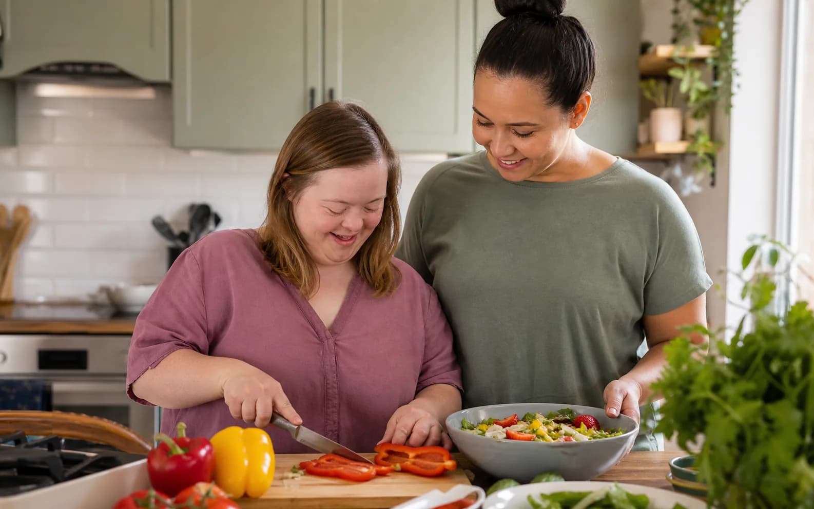 An adult with Down syndrome preparing a meal with an encouraging home caregiver